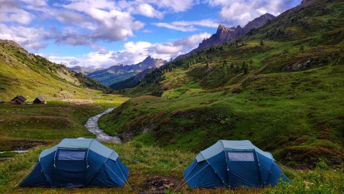 a couple of tents sitting on top of a lush green hillside