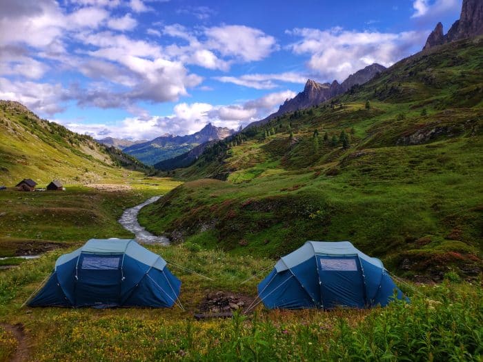 a couple of tents sitting on top of a lush green hillside