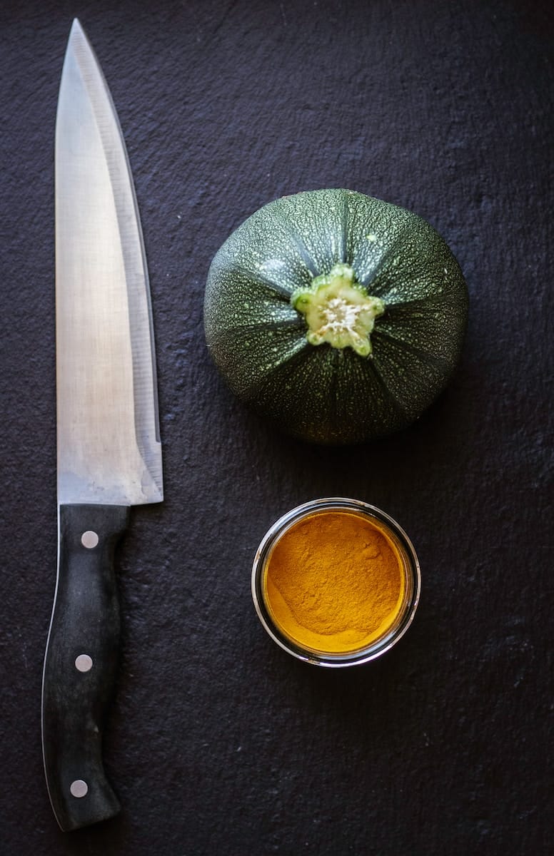 black handled knife beside green vegetable