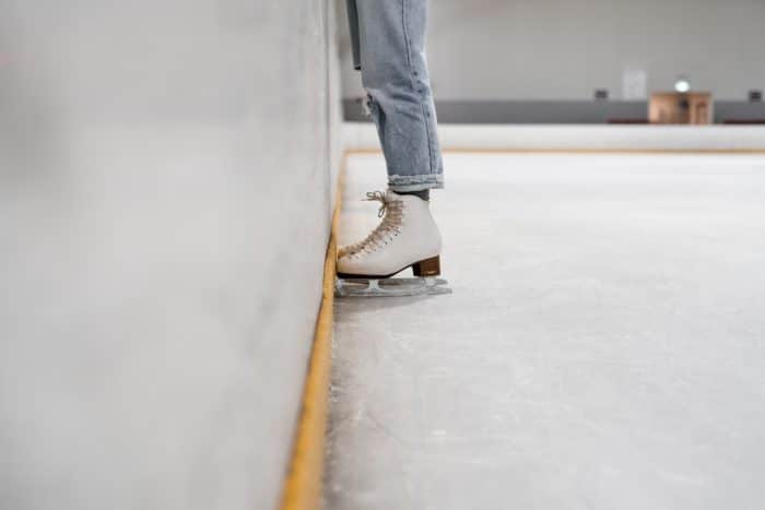 Sortie à la patinoire 1 person wearing white and gray skate shoes inside ice skating rink