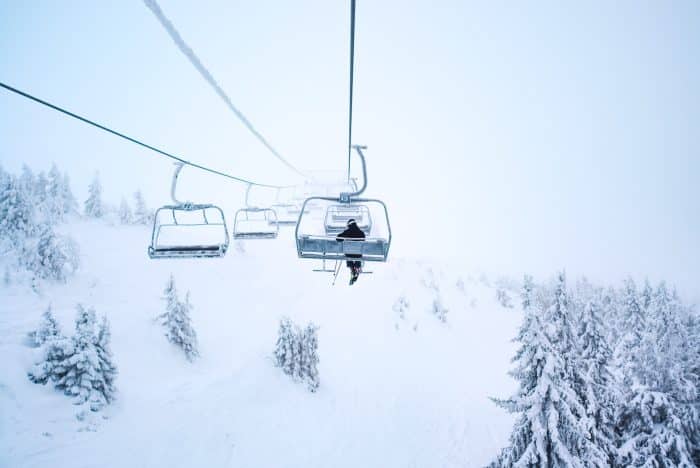 person riding cable train above snow covered field