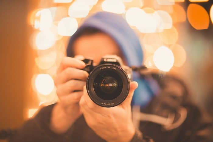 Initiation photo 1 man holding Canon DSLR camera